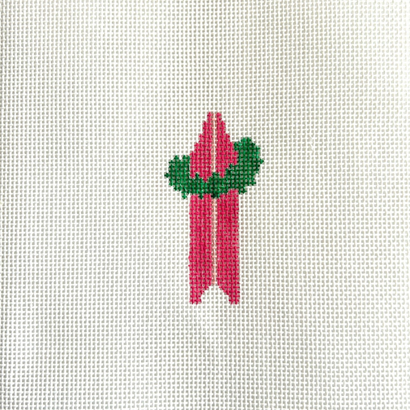 Needlepoint design of a pink surfboard with a light pink stipe and a green holiday wreath.