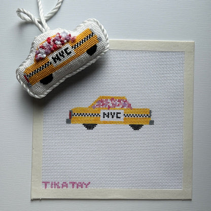 Needlepoint canvas of a New York City taxi with flowers and the finished  ornament above.