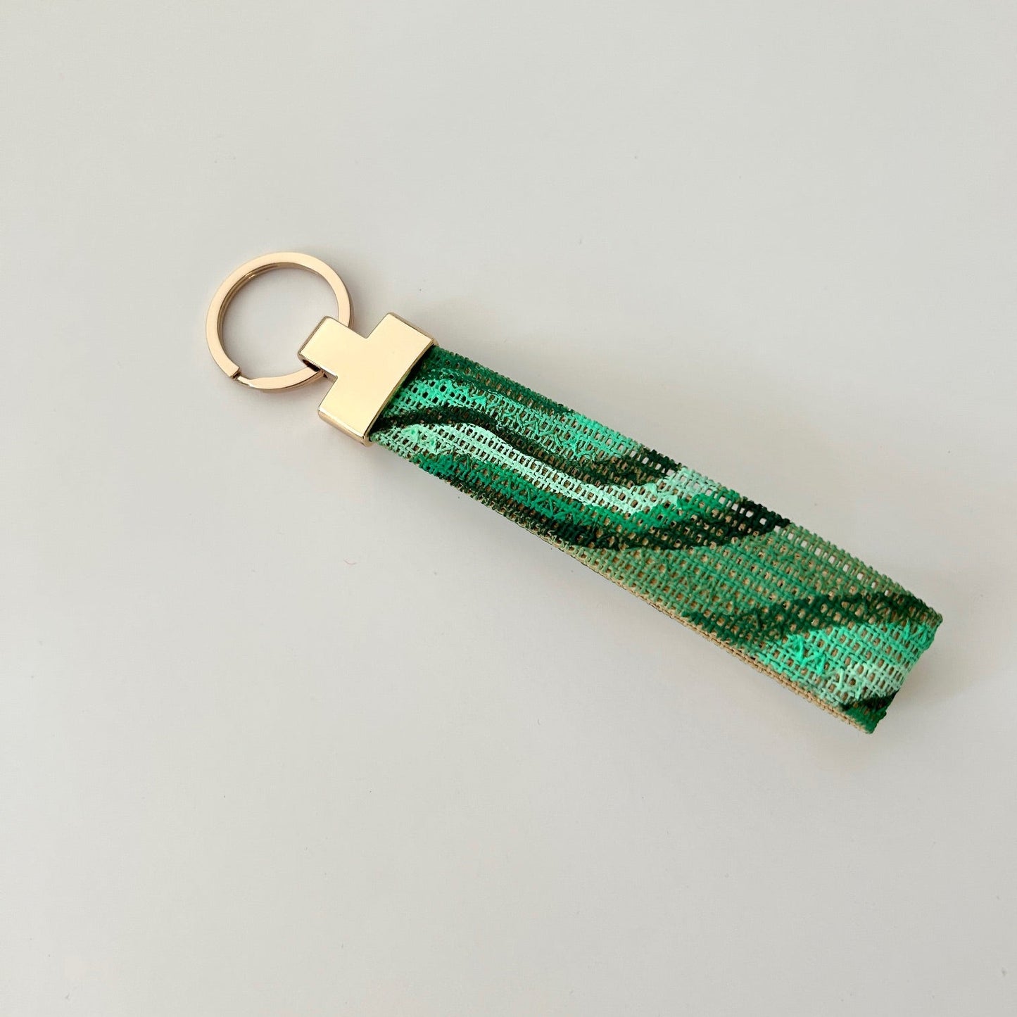 Green malachite print keychain with gold hardware on a white background