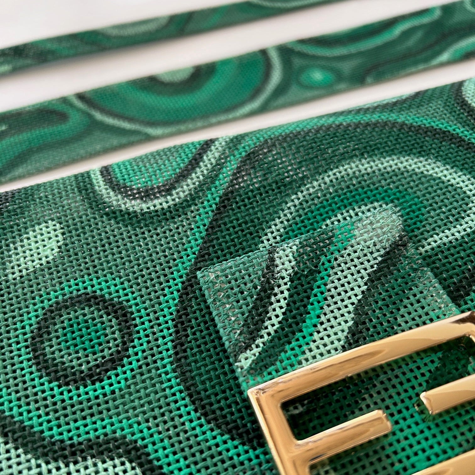 Closeup of needlepoint bag kit in hand painted malachite pattern.