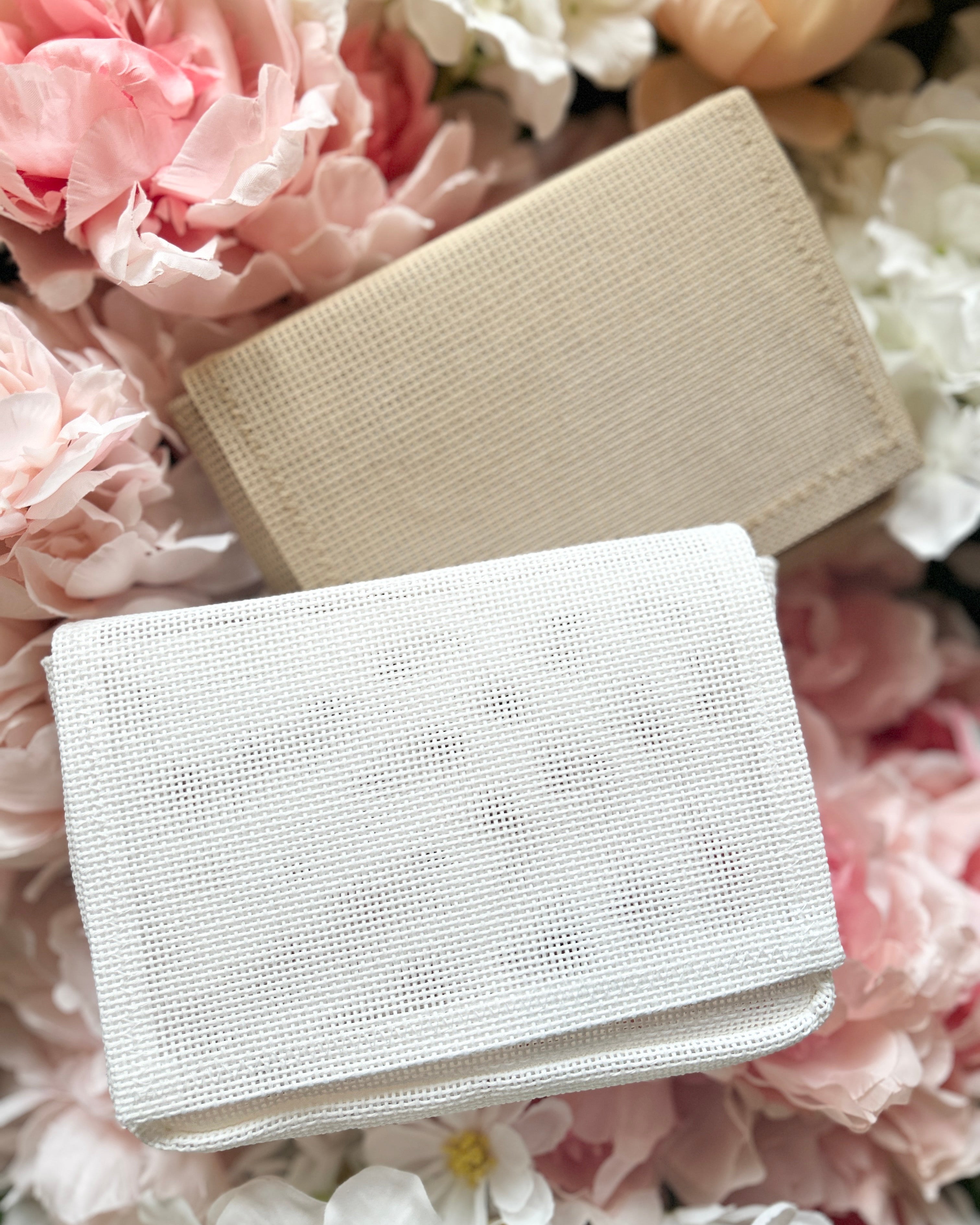 Mini Ready to Stitch Needlepoint bags on floral background.