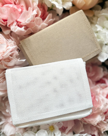 Mini Ready to Stitch Needlepoint bags on floral background.