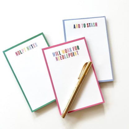 Three colorful Needlepoint notepads on white background with a gold pen.