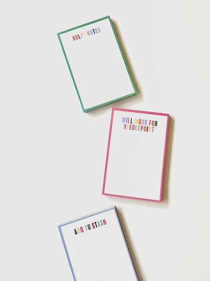 Three colorful needlepoint notepads with text on a white background